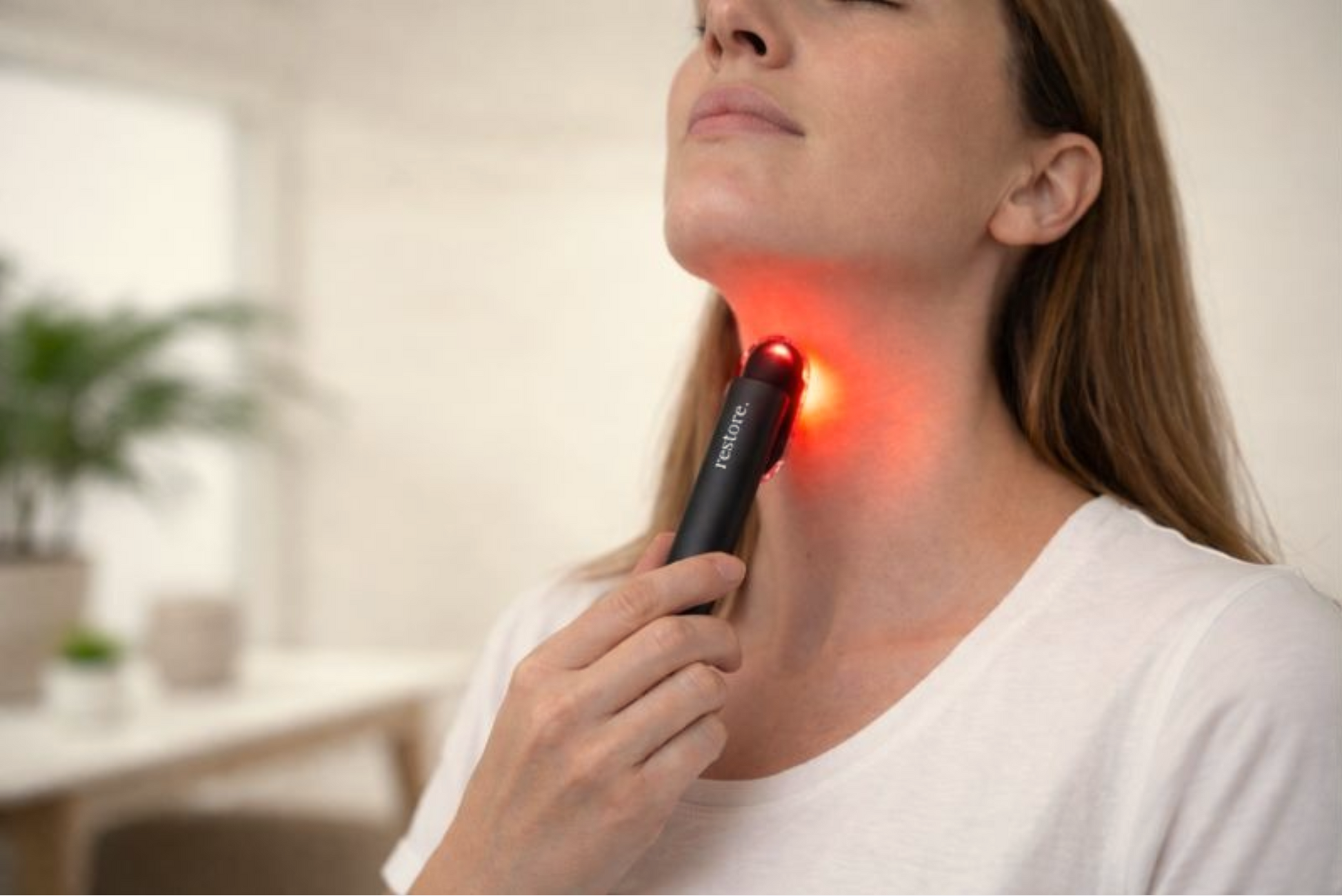 Woman using targeted red light device.